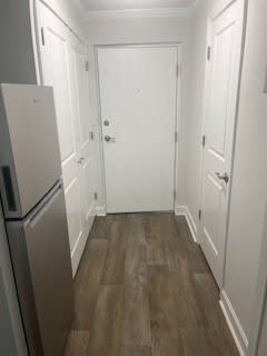A kitchen with a white fridge and a white door.