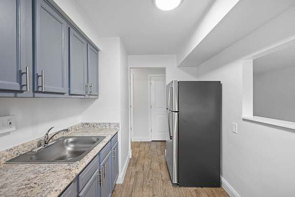 A kitchen with a sink and a refrigerator.