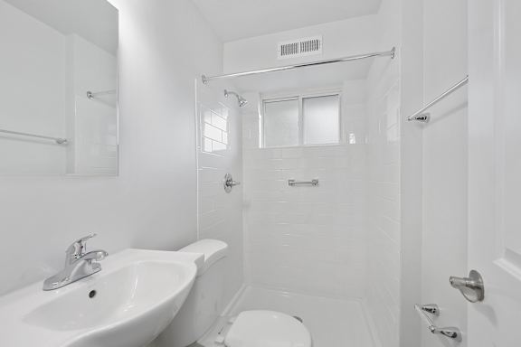 A white bathroom with a sink, toilet, and bathtub.