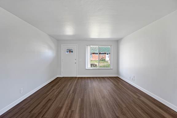 A room with wooden floors and white walls.