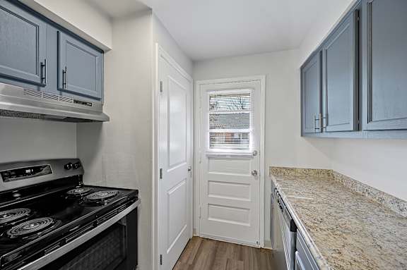 A kitchen with a stove top oven and cabinets.
