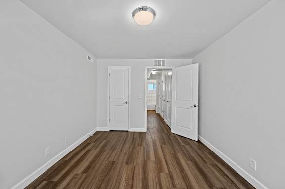 A long hallway with white doors and wood floors.