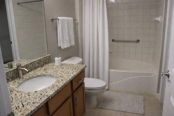 A bathroom with a sink, toilet, and shower.