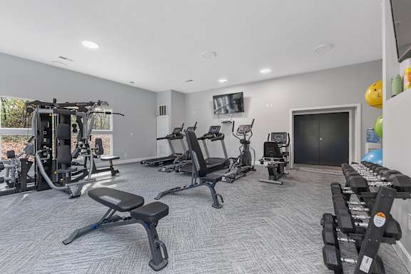A spacious home gym with a variety of exercise equipment.