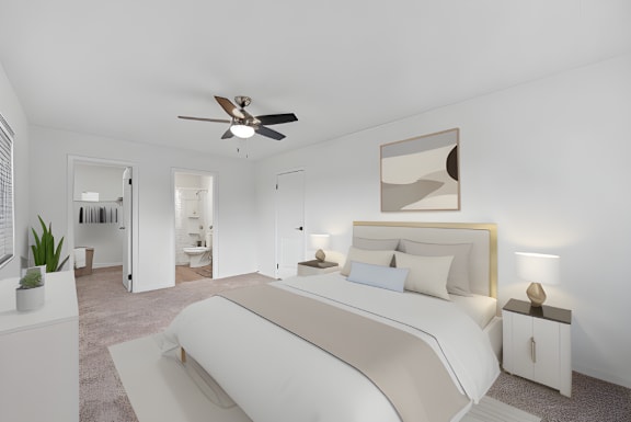 A bedroom with a large bed and a ceiling fan.