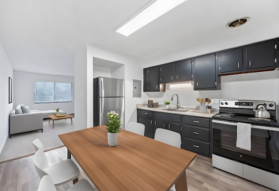 A modern kitchen with a wooden table and white chairs.