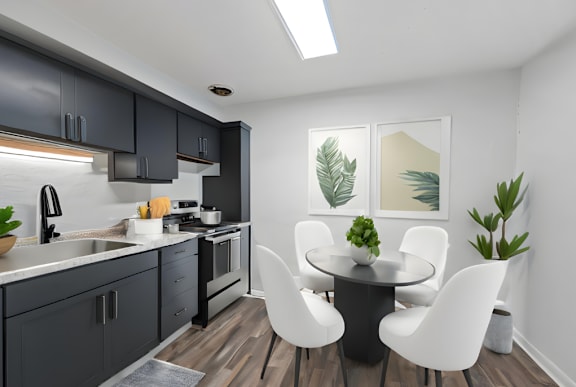 A modern kitchen with a black table and white chairs.