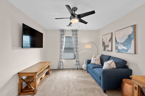 Living room with a blue couch and a ceiling fan at Four Bridges, Ohio
