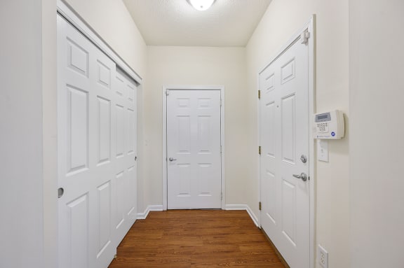 Hallway with white closets and doors and a wood floor at Four Bridges, Liberty Township, Ohio