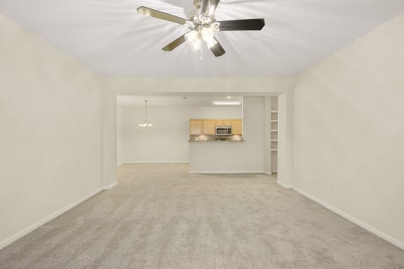 Empty living room with a ceiling fan and a kitchen at Four Bridges, Liberty Township, Ohio