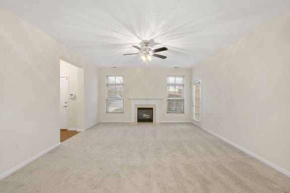 Empty living room with a ceiling fan and a fireplace at Four Bridges, Liberty Township, OH