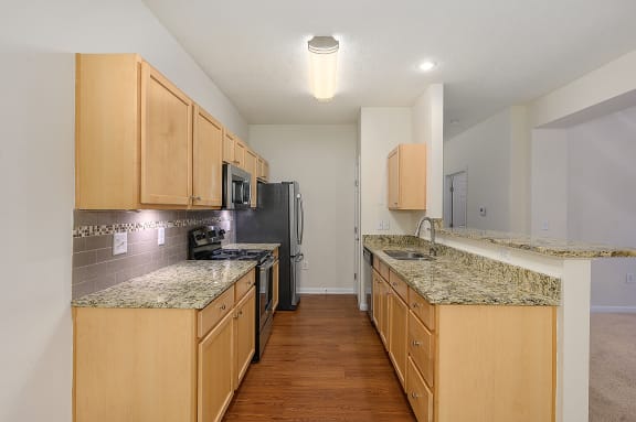 Kitchen with granite counter tops and stainless steel appliances at Four Bridges, Liberty Township
