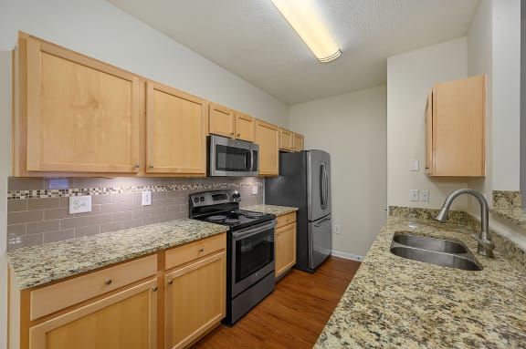 Kitchen with granite counter tops and black appliances at Four Bridges, Liberty Township, 45044-8380