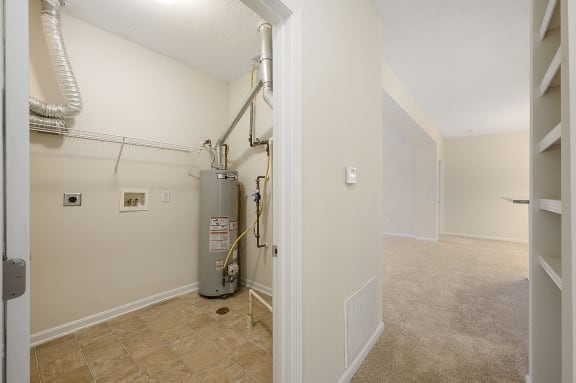 Empty room with a water heater in it and a hallway with a door open at Four Bridges, Liberty Township