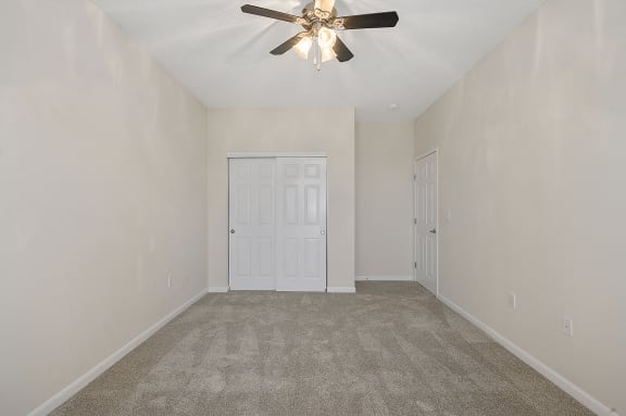 Empty living room with carpet and a ceiling fan at Four Bridges, Ohio