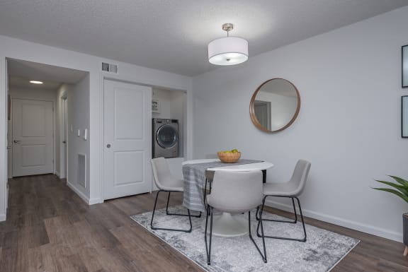a living room and dining room with a table and chairs and a washing machine