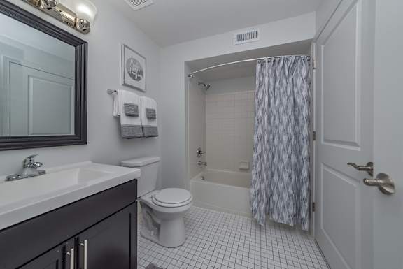 A bathroom with a toilet, sink, and shower.