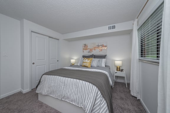 a bedroom with a large bed and a window