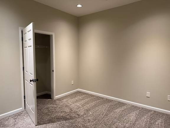 A room with a carpeted floor and a door open to another room.