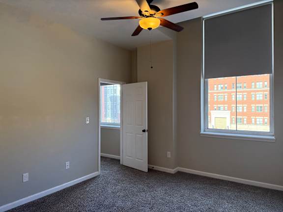 A room with a ceiling fan and a window.