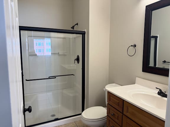 A bathroom with a toilet, sink, and shower.