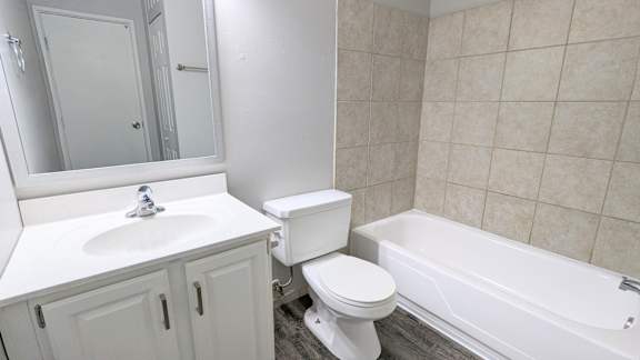 A white bathroom with a sink, toilet and bathtub.