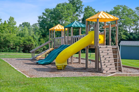 Playground with a yellow and blue slide at Galbraith Pointe Apartments and Townhomes, 45231
