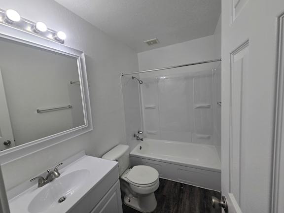 A white bathroom with a sink, toilet, and bathtub.