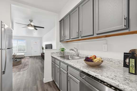 A kitchen with a marble countertop and a bowl of fruit on it.