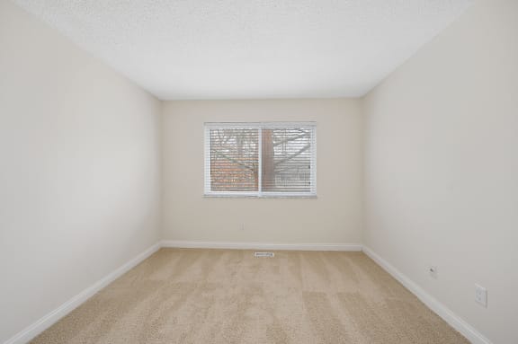 a spacious living room with carpet and a window at Harpers Point Apartments, Cincinnati, Ohio