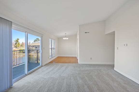 an empty living room with a balcony and a door to a balcony at Harpers Point Apartments, Cincinnati, 45249