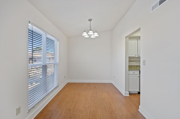 an empty living room with a large window and wood flooring at Harpers Point Apartments, Cincinnati