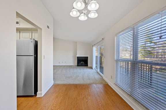 an empty living room with a large window and a refrigerator at Harpers Point Apartments, Cincinnati, 45249