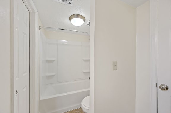 an empty bathroom with a toilet and a shower in it at Harpers Point Apartments, Cincinnati, Ohio