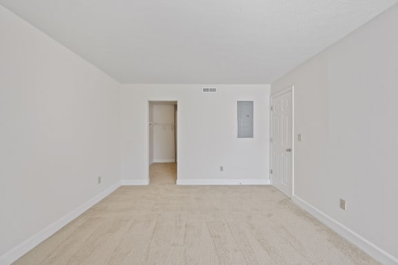 a spacious living room with white walls and a white door to a closet at Harpers Point Apartments, Cincinnati, Ohio