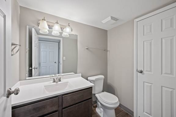 A bathroom with a white sink and toilet.