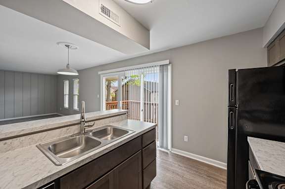 A kitchen with a sink and a refrigerator.