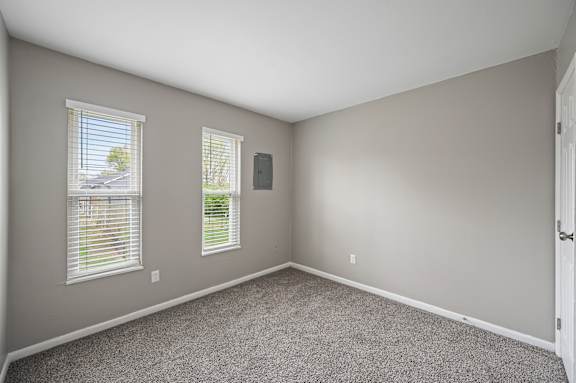 A room with two windows and a door.