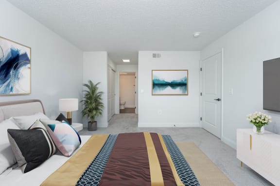 a spacious bedroom with a large bed and a view of the living room and bathroom