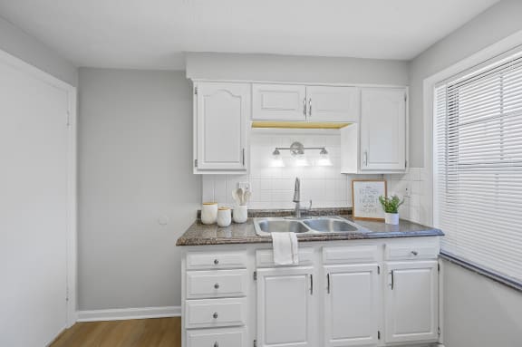 a kitchen with white cabinets and a sink and a window at Huntley Ridge, Kettering, OH, 45419