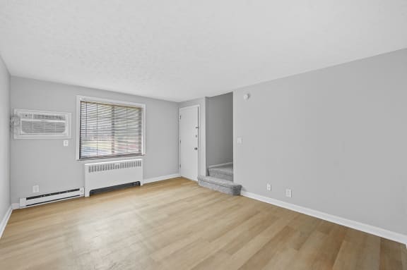 the living room and dining room of an apartment with wood flooring and a window at Huntley Ridge, Ohio, 45419