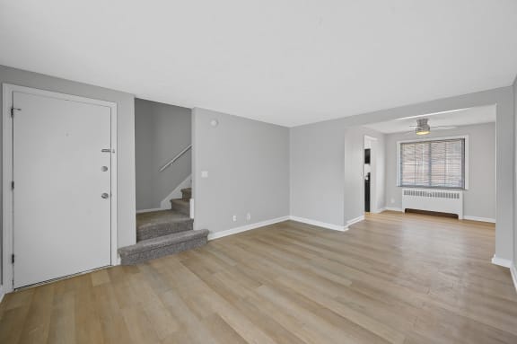 the living room and entryway of an empty house with white walls and wood floors at Huntley Ridge, Ohio, 45419