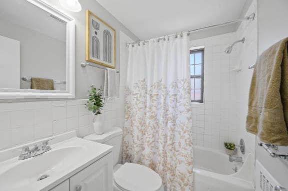 a bathroom with a shower curtain and a sink and a toilet at Huntley Ridge, Kettering