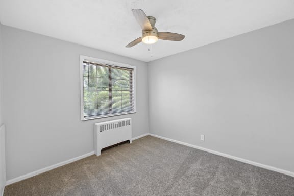 an empty bedroom with a ceiling fan and a window at Huntley Ridge, Kettering, OH, 45419