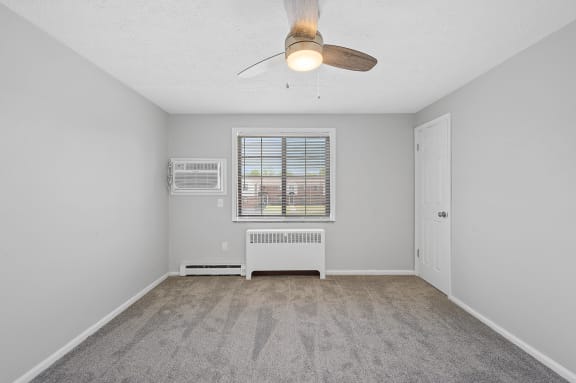 an empty living room with a ceiling fan and a window at Huntley Ridge, Kettering