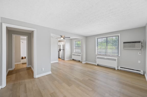the living room and dining room of an empty house with wooden floors and a ceiling at Huntley Ridge, Ohio