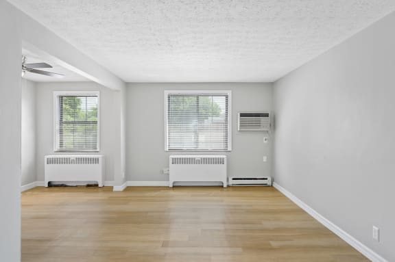 the living room of an empty house with wood floors and white walls at Huntley Ridge, Kettering, OH, 45419