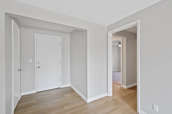 an empty room with white walls and a wood floor at Huntley Ridge, Kettering