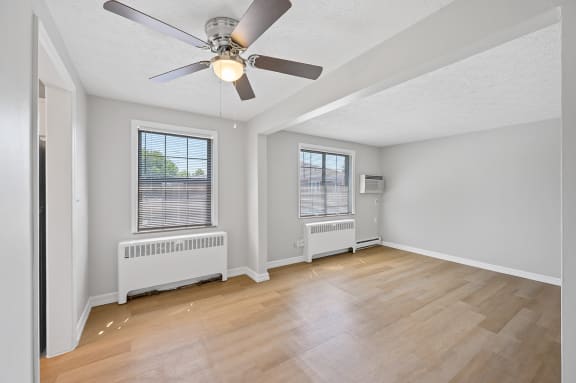 an empty living room with a ceiling fan and two windows at Huntley Ridge, Kettering, OH, 45419