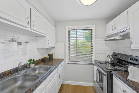 a kitchen with a sink and a stove and a window at Huntley Ridge, Kettering